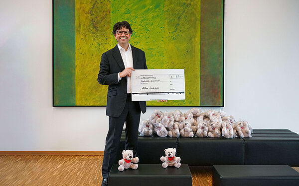 Managing Director Albrecht Sieper with donation cheque and teddy bears