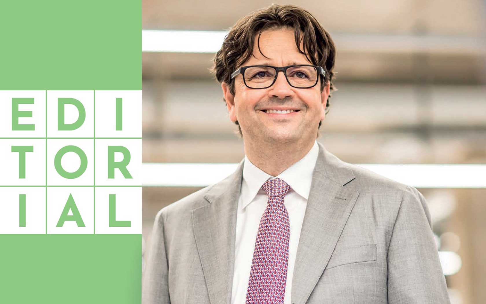Dark haired man next to a green box with the text editorial